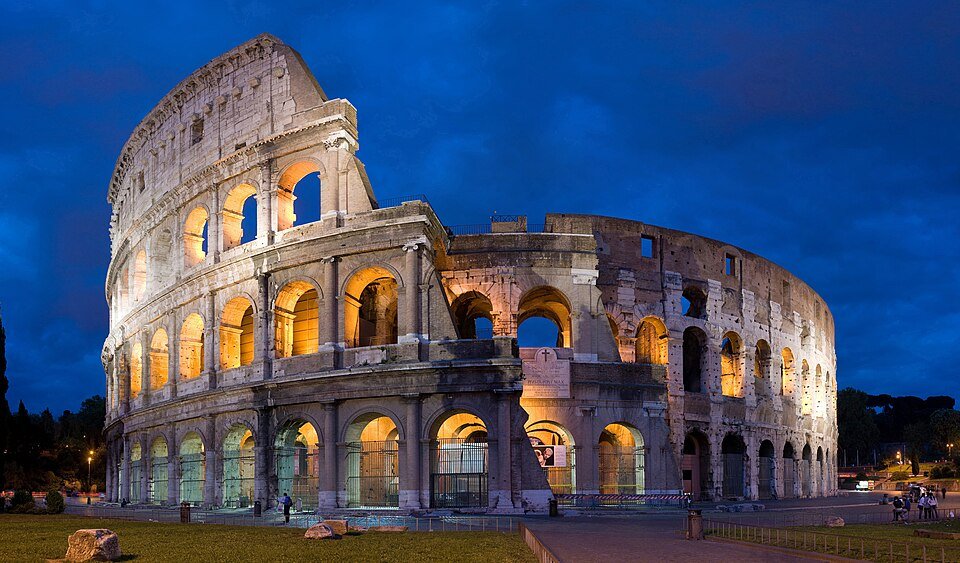 The Colosseum illuminated against a blue evening sky