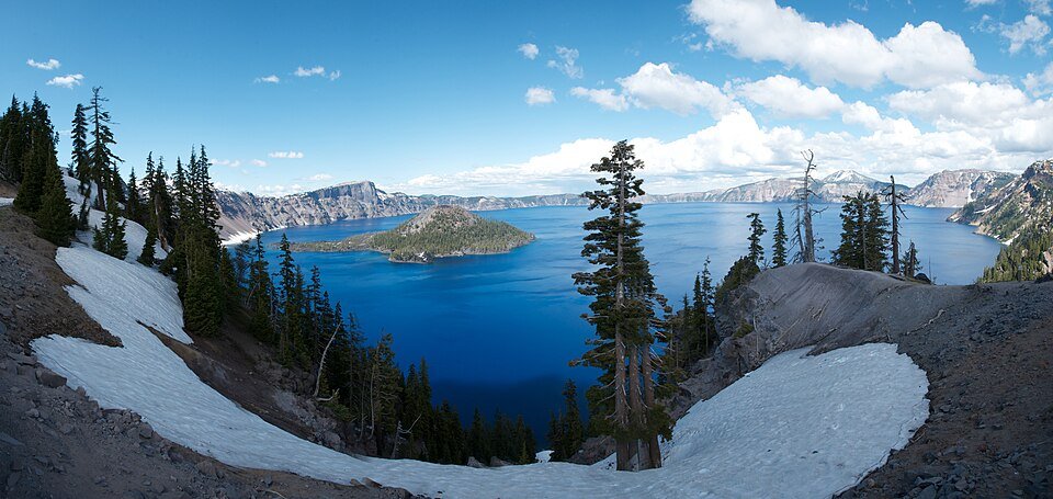 The blue water and wooded shores of Crater Lake, Oregon